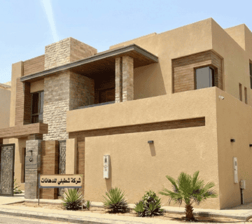 واجهة فيلا مودرن في جدة تم تنفيذها بواسطة مقاول دهانات جدة شركة شطبلي، تظهر دهانات البروفايل الخارجي بألوان رملية عصرية وتنسيق حدائق 
